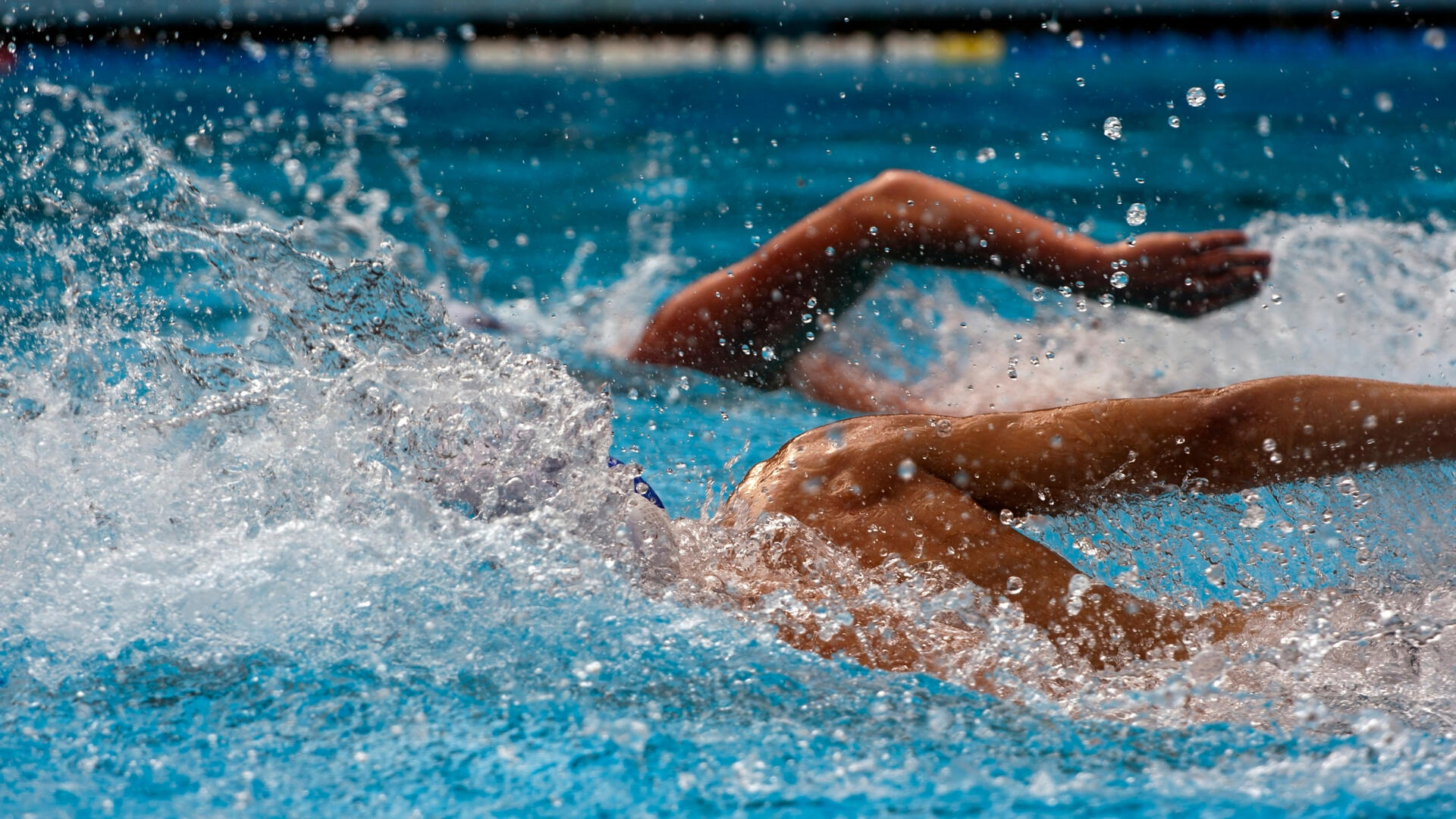 Two swimmers competing in swimming lessons together.